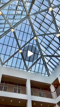 an atrium with glass walls and ceiling lights