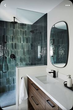 a bathroom with two sinks, mirrors and a shower head mounted on the side of the wall