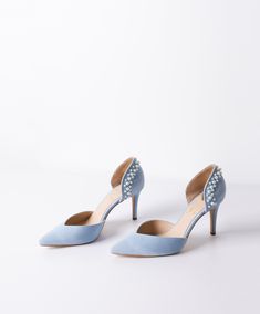 a pair of blue high heeled shoes with pearls on the toe and heels are shown