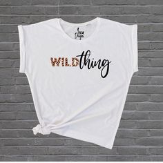 Ladies 'Wild Thing' Leopard Print White Tshirt. A beautiful, soft, relaxed fit tshirt with rolled cap sleeves. True to size. Size guide: S (UK 8/10) M (UK 10-12) L (UK 12-14) Made from 100% Ringspun Combed Cotton. Additional sizes available on request in Black, White, Grey and Navy: XL (UK 16) XXL (UK 18)  (XL & XXL sizes only: Made from 70% Cotton, 30% Polyester (Grey: 90% Cotton, 10% Viscose). Machine wash inside out, max. 30oc) Care instructions (sizes S-L): Machine wash inside out, max. 40oc Pre-shrunk White Print Graphic Tee, White Print Pre-shrunk Graphic Tee, White Graphic Tee With Text Print, White Print Graphic Tee With Text, White Print Top With Text Print, Relaxed Fit, Relaxed Fit Tshirt, Animal Print Shirt, Animal Print Shirts, Stay Wild