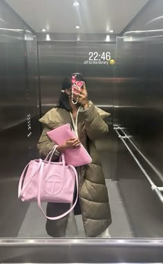 a woman is taking a selfie in an elevator