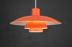 an orange and white light hanging from a ceiling