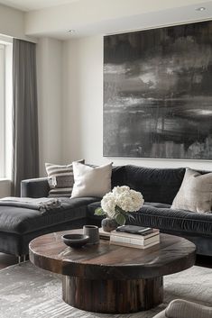 a living room with two couches and a coffee table in front of a large painting