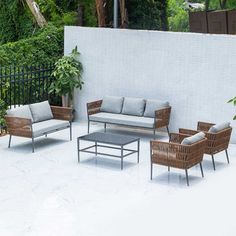 an outdoor patio with wicker furniture and potted plants