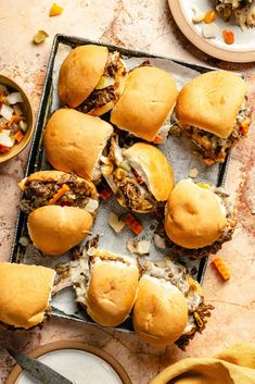 several sliders with meat and vegetables on a tray