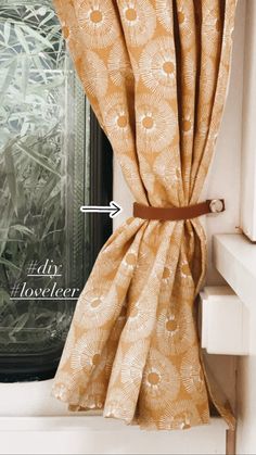 the curtain is pulled back to reveal an interesting pattern on the window sill and tie it with a brown leather belt