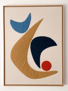 an abstract painting with blue, brown and red shapes on white paper in a wooden frame