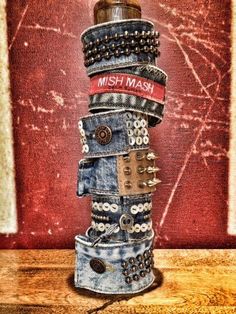 a stack of jeans with metal rivets and buttons on them sitting on top of a wooden table