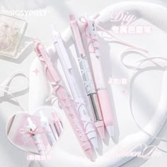 three pink pens sitting on top of a white plate next to a pair of scissors