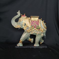 an elephant figurine is on display against a black background