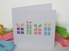 a white card with colorful designs on it next to some ribbons and ribbon clips in the background