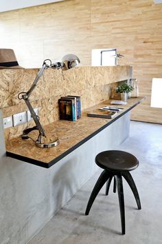 a desk with a lamp on top of it next to a chair and bookshelf