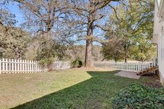 the back yard is fenced off with trees