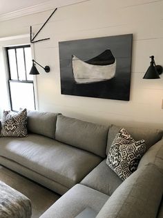 a living room filled with furniture and a large painting hanging on the wall above it