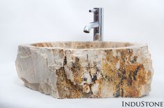 a sink made out of stone with a faucet