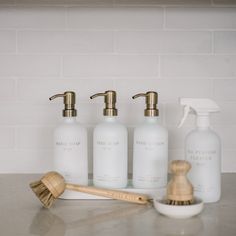 four bottles and a brush on a counter