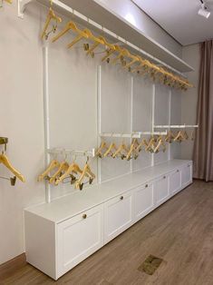 there is a white shelf with gold clothes hangers on it