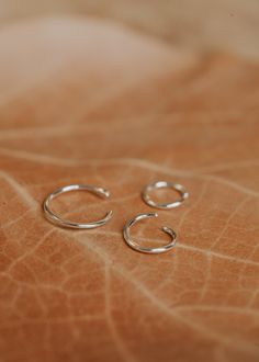 Sterling silver hoop earring shown in three sizes of 5MM Everyday Small Hoop Hammered Huggie Earrings, Dainty Hammered Hoop Earrings, Tiny 14k Gold Filled Hoop Earrings, Adjustable Tiny Small Hoop Jewelry, Tiny Adjustable Hoop Earrings, Ear Stacks, Twist Earrings, Copper Uses, Everyday Wear Jewelry