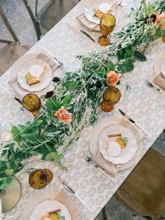 an overhead view of a table set with plates and flowers on it, along with other place settings