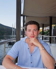 a man sitting at a table in front of water