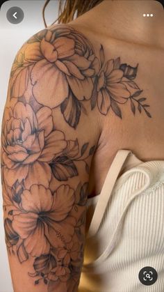 a woman's arm with flowers on it, and the back of her shoulder