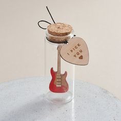 a corked guitar in a glass jar with the words i pick you written on it