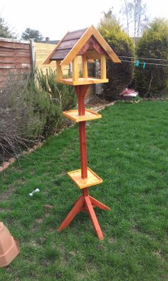 a bird house on a stand in the yard