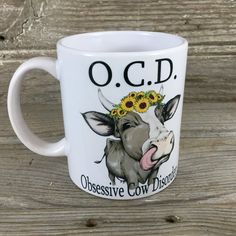 a white coffee mug with a cow and sunflower on it's head that says o c d obsesive cow medicine