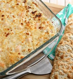 a casserole dish with cheese and crackers on the side