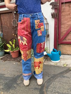 a person standing in front of a building wearing patchwork jeans