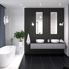 a black and white bathroom with two sinks, mirrors and bathtub in the corner