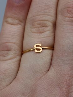 This elegant gold initial ring is perfect for stacking, making it a great gift for any occasion - whether a mother's day surprise or a best friend's birthday present. Crafted from quality stainless steel, this letter ring will look beautiful for years to come. Featuring a letter of your choosing, this ring can be worn alone or stacked making it perfect for gifting to friends or family. The subtle, yet sweet letter ring looks elegant alone or as part of a larger stack. This gold letter ring is th Dainty Gold Stackable Rings With Initials, Simple Anniversary Rings With Initials, Simple Anniversary Ring With Initials, Simple Gold Initial Ring For Anniversary, Everyday Gold Monogram Initial Ring, Gold Monogram Initial Ring For Everyday, Gold Monogram Initial Ring For Everyday Wear, Simple Personalized Gold Stackable Rings, Gold Stainless Steel Stackable Rings For Gift