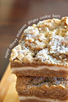 three pieces of cake sitting on top of a wooden cutting board with the words ginger cookie bars above it