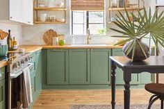 a kitchen with green cabinets and wooden floors