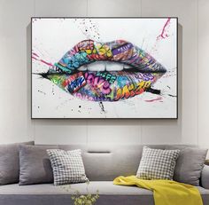 a living room with a couch and large painting on the wall above it that has colorful lips