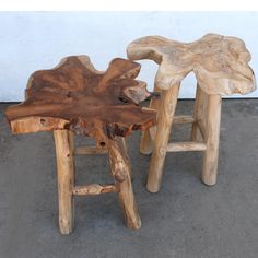 two wooden stools made out of logs sitting on the ground next to each other