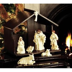 a nativity scene with figurines in front of a fireplace