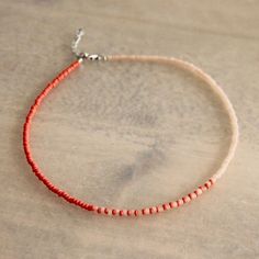 a red beaded bracelet on a wooden table