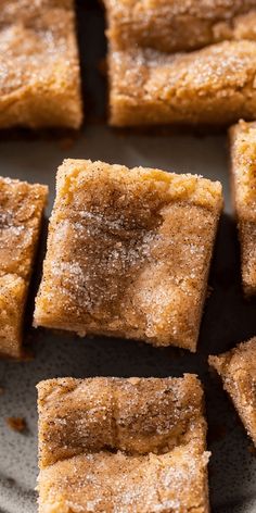 several pieces of cake sitting on top of a white and gray plate with powdered sugar