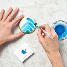 someone is painting something blue on a cookie