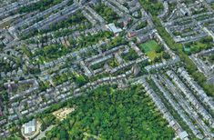 an aerial view of a large city with lots of trees and houses in the background