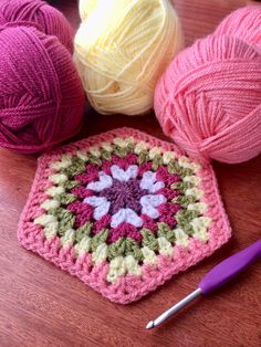 balls of yarn and crochet are sitting on a table