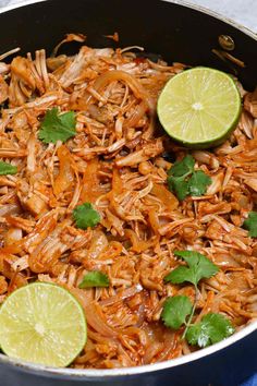 shredded chicken with limes and cilantro in a skillet