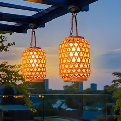 two lights hanging from the ceiling in front of a cityscape