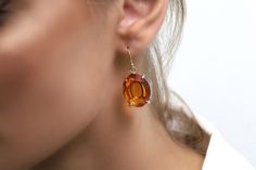 These earrings are handcrafted to perfection, featuring a large oval-shaped citrine gemstone that shines beautifully in the light. As the birthstone for November, these earrings make a perfect gift for anyone born in that month or for anyone who loves the warm, vibrant color of citrine, The gold filled setting adds a touch of luxury to these already stunning earrings, making them perfect for special occasions. The dangle design ensures that they catch the light with every movement, drawing atten Yellow Oval Citrine Earrings, Oval Citrine Gemstone Earrings, Elegant Oval Citrine Earrings, Oval Gold Topaz Earrings, Elegant Amber Oval Earrings, Oval Topaz Earrings For Gift, Oval Topaz Earrings As Gift, Movement Drawing, Orange Gem