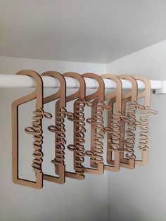 a bunch of wooden signs hanging from a white wall next to a mirror on a rod