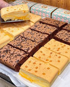 there are many different desserts on the table and one is cut into squares with a knife