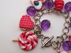 a close up of a bracelet with candy and lollipops on the chain