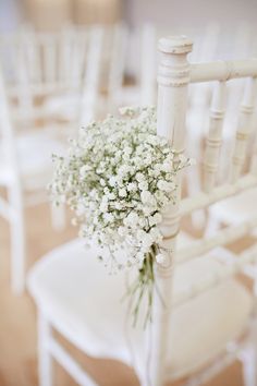 a bouquet of baby's breath sitting on top of a white chair in a room