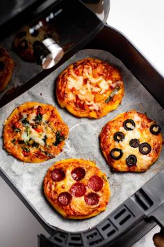 four mini pizzas sitting on top of an oven